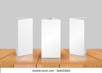 Blank Table Tent isolated on wooden table background. Paper vertical triangle cards on white background with reflections. Front. left and right view. Vector illustration.