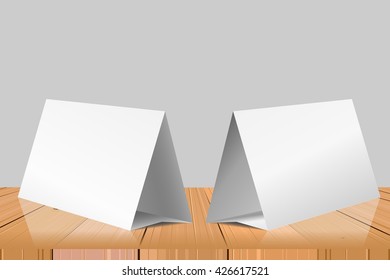 Blank Table Tent isolated on wooden table background. Paper horizontal triangle cards on white background with reflections. Front. left and right view. Vector illustration.