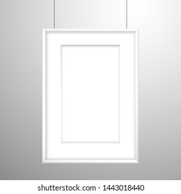 Blank white frame with passe-partout for an image or poster hanging on threads