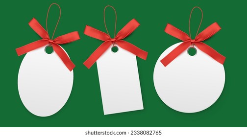Blank white labels with red bow isolated on green background.