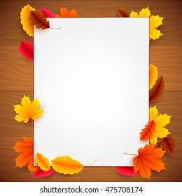 Blank white paper list and colorful autumn leaves on old wood background. Greeting or advertisment template
