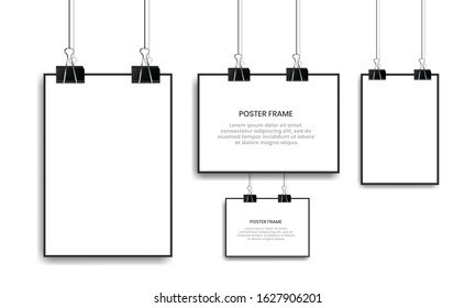 Blank white poster hanging with binder clips.
