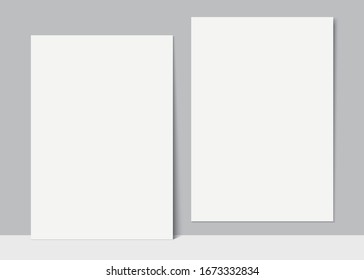 Blank white posters hanging and leaning against the wall. Set of white vector canvas templates. Realistic poster mockups.