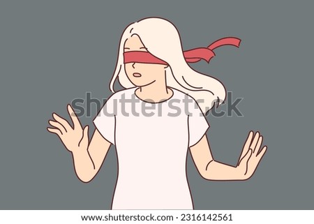 Blindfolded woman cannot navigate in space due to forced blindness and turns with frightened emotions. Blindfolded teenage girl plays hide-and-seek and waits for peers to find place to hide