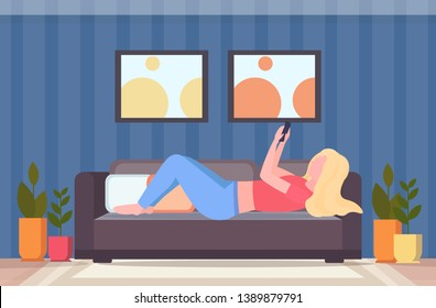 blonde woman lying on couch girl taking selfie photo on smartphone camera modern living room interior female cartoon character flat full length horizontal