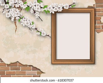 Blooming branches and golden picture frame on old wall background. Weathered plastered surface with cracks and brickwork.
