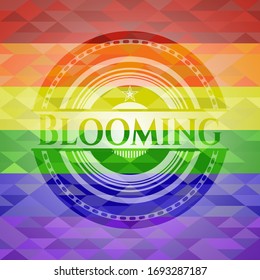emblema floreciente sobre fondo de mosaico con los colores de la bandera LGBT