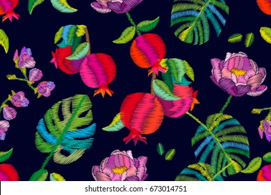 Blooming pomegranate garden. Seamless vector pattern with exotic fruits, palm leaves and flowers. Embroidered texture. Vintage textile collection.