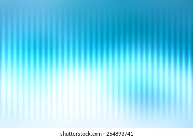Blue abstract blur colored background with defocused vertical rays of light.