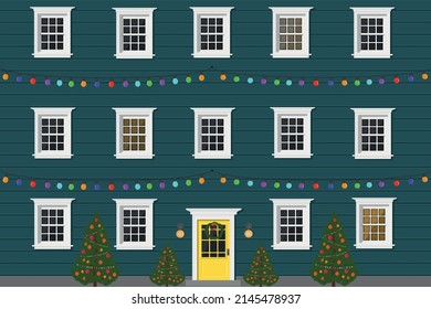 blue apartment building with a door and windows in the evening with a garland for the holiday and christmas tree