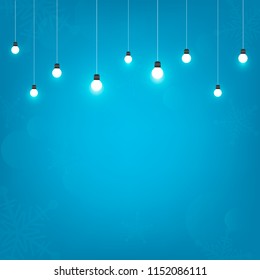 Blue background with hanging light bulb design for christmas
