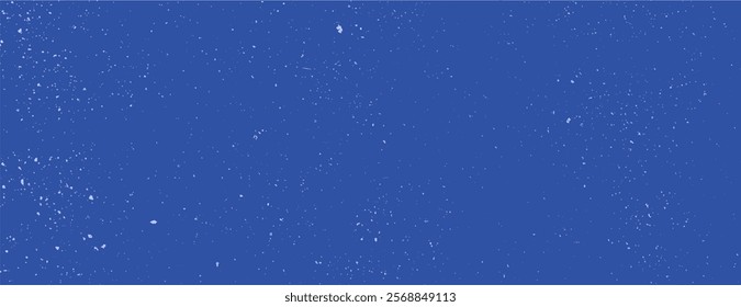 A blue background with a speckled texture. The background is blue with a starry effect, creating a cosmic style. Speckled wall texture background. Blue background vector.