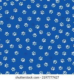 Blue background with white paw prints seamless fabric pattern