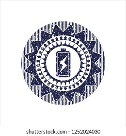 Blue battery charging icon inside rubber seal with grunge texture