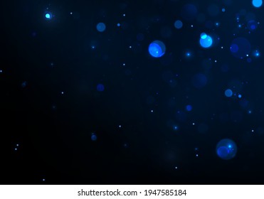 Blue bokeh light on dark background. Abstract glitter defocused blinking stars and sparks.