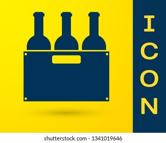 Blue Bottles of wine in a wooden box icon isolated on yellow background. Wine bottles in a wooden crate icon. Vector Illustration