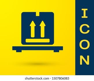 Blue Cardboard boxes on pallet icon isolated on yellow background. Closed carton delivery packaging box with fragile signs.  Vector Illustration