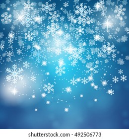 Blue Christmas background with snowflakes and bright light