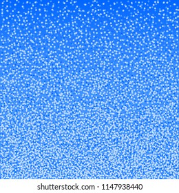 Blue christmas background, winter snowfall pattern. Falling white snowflakes on bright backdrop for season greeting card.