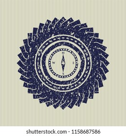 Blue compass icon inside distress rubber grunge seal
