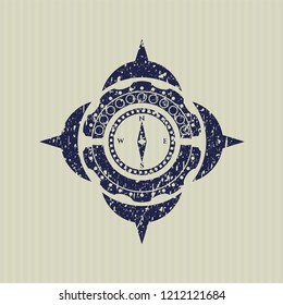 Blue compass icon inside distressed rubber stamp with grunge texture