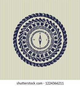 Blue compass icon inside distressed grunge seal