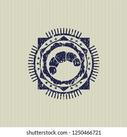 Blue croissant icon inside distressed rubber grunge texture stamp
