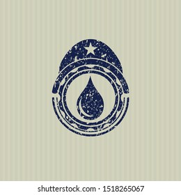 Blue drop icon inside rubber seal with grunge texture