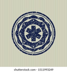 Blue emergency cross icon inside distressed rubber texture