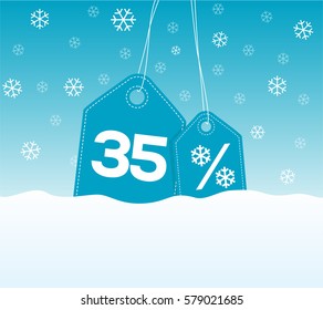 Blue hanging price tag labels with 35% and snowflake percent design texts on them on snow background. For winter sale campaigns.