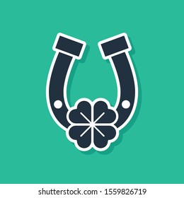 Blue Horseshoe with four leaf clover icon isolated on green background. Happy Saint Patricks day.  Vector Illustration