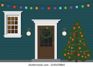 blaues Haus mit Tür und Fenster abends mit einer Gartenanlage für Feiertage und Weihnachtsbaum