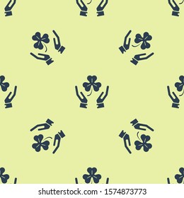 Blue Human hands holding four leaf clover icon isolated seamless pattern on yellow background. Happy Saint Patrick day.  Vector Illustration