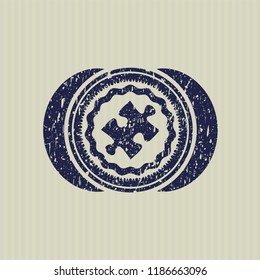 Blue jigsaw puzzle piece icon inside rubber stamp with grunge texture