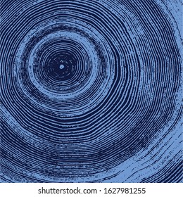 Blue natural stamp of wood texture of tree rings from a slice of log. Contrast negative monotone image of cut tree.