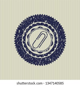 Blue paper clip icon inside distressed rubber seal