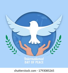 Blue Paper Cut Circle Shape Earth Globe Background with Hands Releasing Dove and Green Olive Leaf Branches for International Day Of Peace.