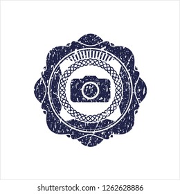 Blue photo camera icon inside rubber stamp with grunge texture