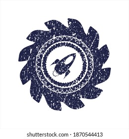 Blue rocket icon inside rubber seal with distressed texture. 