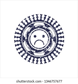 Blue sad face icon inside distressed rubber grunge texture seal
