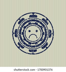 Icono de la cara azul triste dentro de la junta de goma con textura gruesa