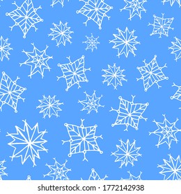Blue seamless pattern with white hand drawn scribble ink snowflakes.