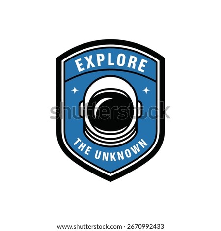 A blue shield-shaped emblem features an astronaut helmet at its center, with the words 'EXPLORE' above and 'THE UNKNOWN' below, alluding to space exploration and discovery.