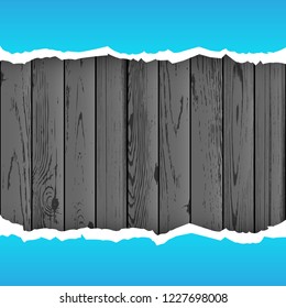 Blue torn paper on dark wood background. Ripped paper on black wooden backdrop