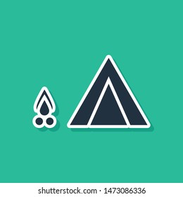 Blue Tourist tent with wood fire icon isolated on green background. Camping symbol.  Vector Illustration