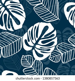 Blue tropical leaves pattern. Tropical seamless pattern with white leaves of monstera, banana and palm trees on a blue background.