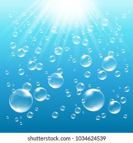 Blue water background with bubbles and sunrays shining into the water