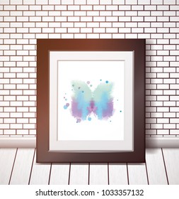 Blue watercolor butterfly in black frame on white brick wall.