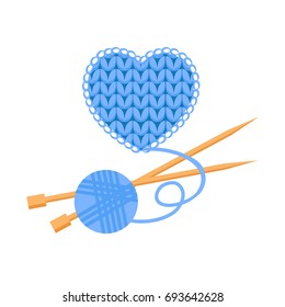 Blue wool knitted heart with a ball of wool and two yarn needles