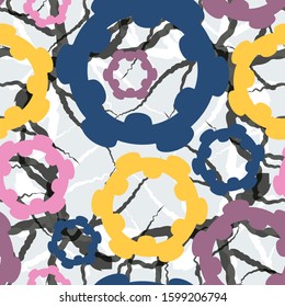 
blue, yellow, pink rings with curly edges of different sizes on a gray with black cracks background. abstract seamless pattern. vector
